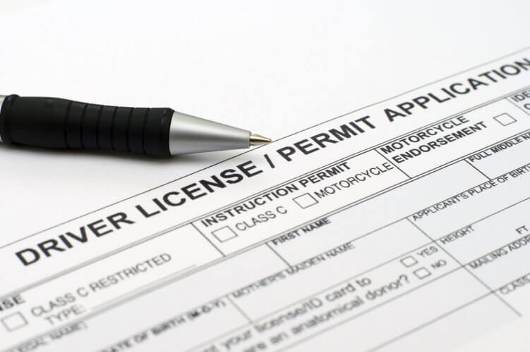 Close up to a driver license/permit application document with pen on top to illustrate how to get a driver's license.