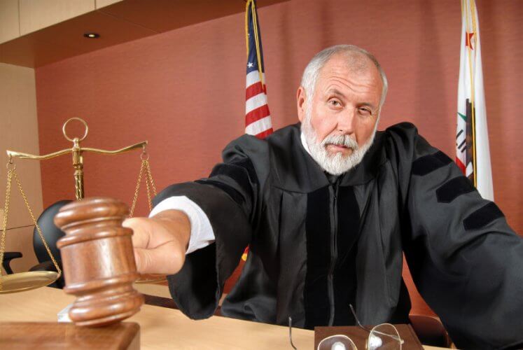 Older, distinguished judge making his ruling with a gavel in the courtroom