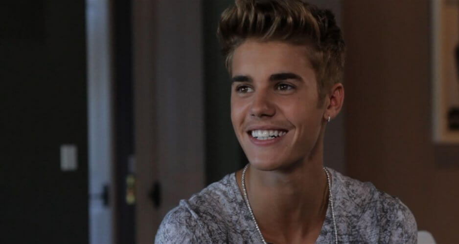Photography of pop star Justin Bieber smiling because he has car insurance