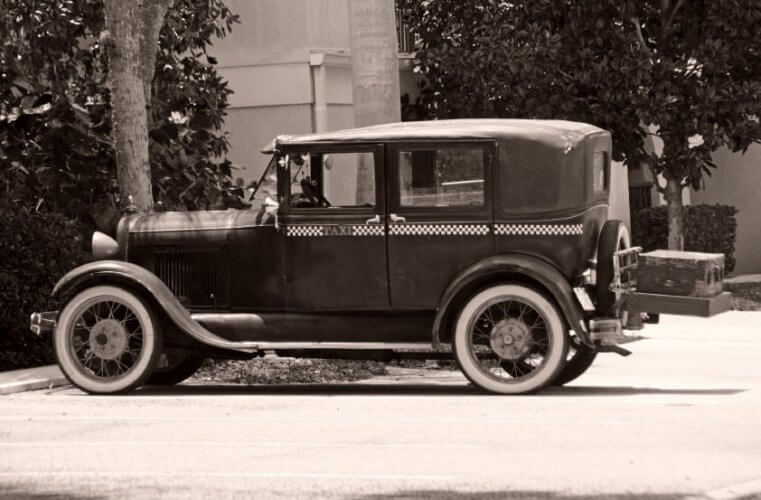 Black and white photography of a vintage taxi cab depicting the history of auto insurance