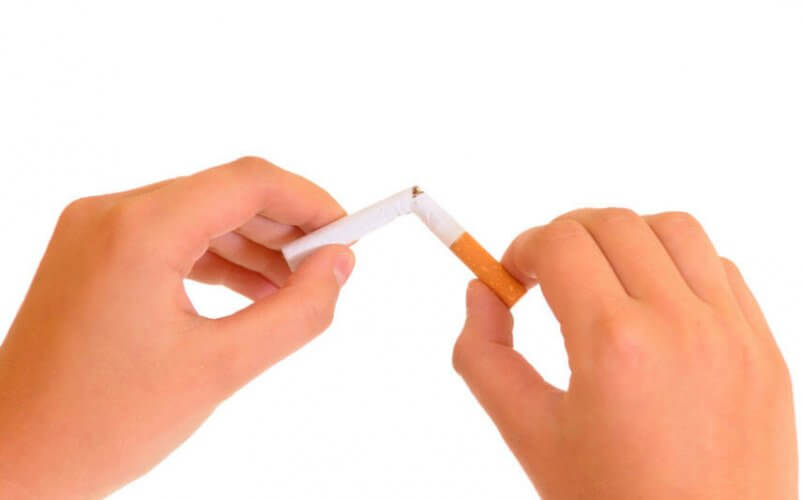 Close up to hands breaking a cigarette in half to illustrate what to do when you want to quit smoking