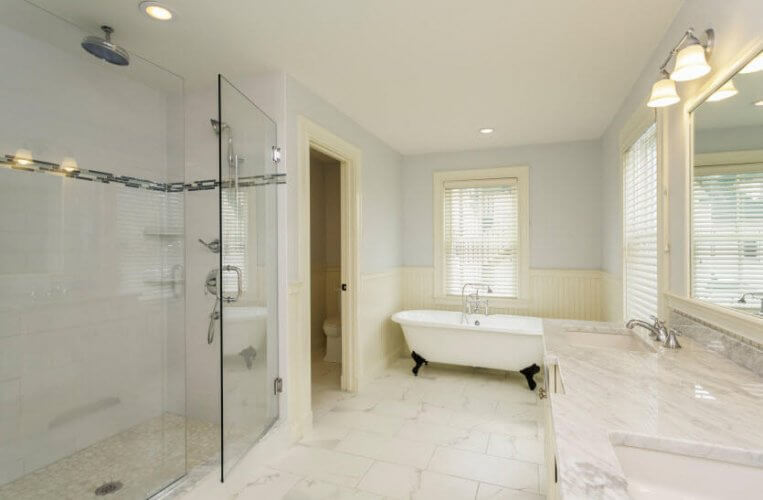 Picture of a luxurious and spacious bathroom with a bathtub, two sinks, big mirror and shower to illustrate how your bathroom can be hazardous