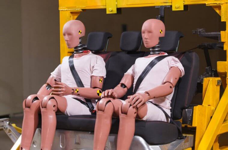 Crash test dummies wearing seatbelts in a car safety simulation to depict how safe is your car