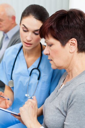 Female young doctor with older patient registering the New York Healthcare late signups for Obamacare