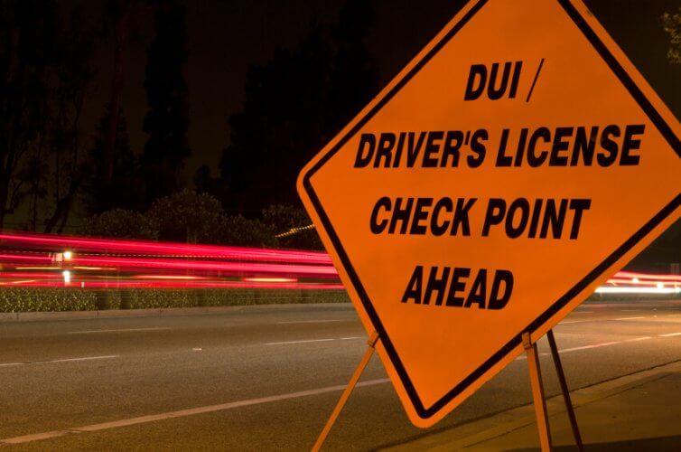 A road sign that reads DUI/ driver's license check point ahead to illustrate DUI Statistics and the Fourth of July