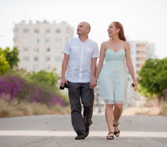 Young couple smiling walking on the road, apartment hunting