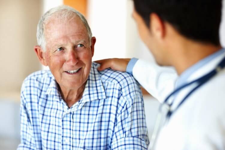 Portrait of a senior man listening to young Latino male doctor.