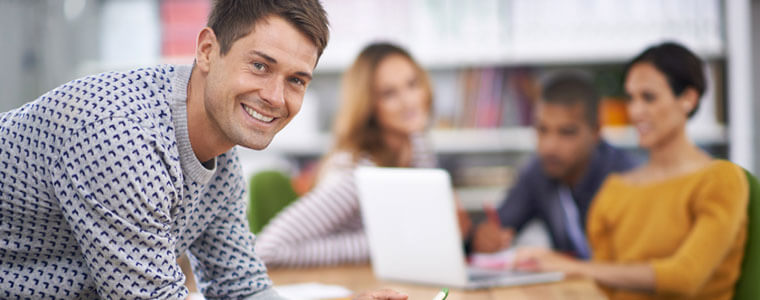 A young Caucasian man sitting by several friends to illustrate Three Reasons You Should Sign up for Obamacare in Austin