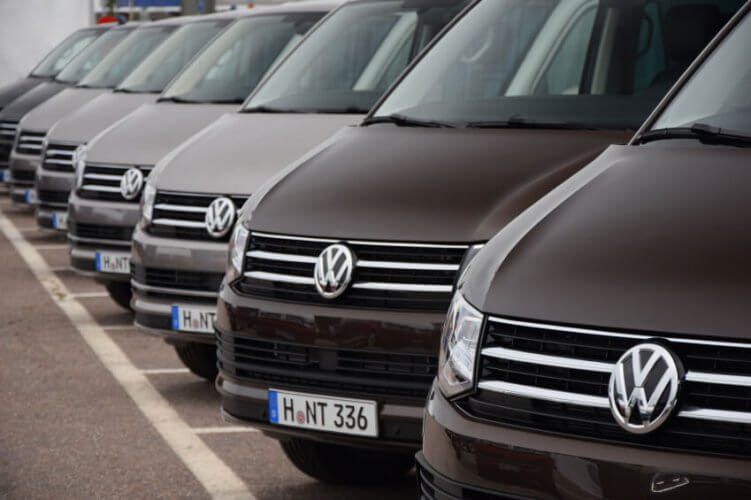 Row of Volkswagen vans parked in a parking lot.