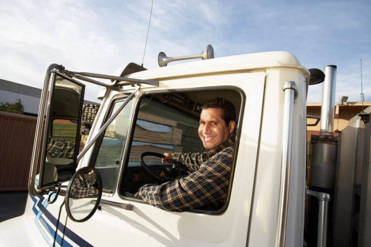 A latino man sitting at the wheel of a commercial truck to illustrate how Is Inadequate Training of Truck Drivers Putting Lives at Risk