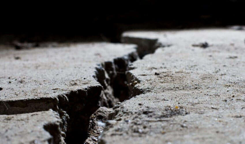 Close-up to a crack on the pavement that illustrates the New Phenomenon of “Frack Quakes”, a Problem for Texas Homeowners