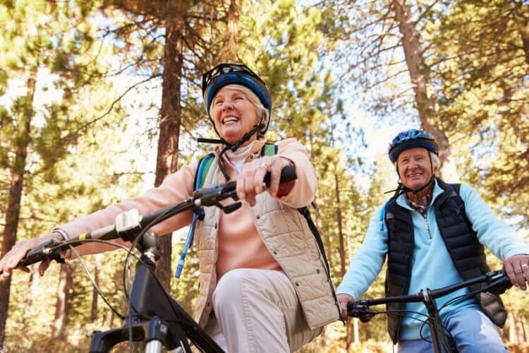 Two senior citizens riding their bikes and illustrating the Best Activities to Keep Busy as a Retiree