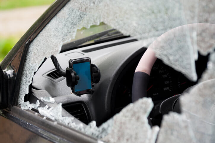 A smashed window on a car driver's side. The SATNAV system was stolen.