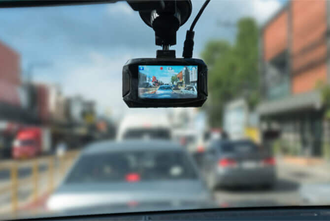 Car driving in traffic with dash cam mounted on windshield to depict the importance of dash cams and DUI cases