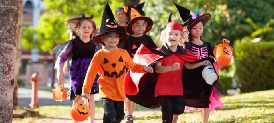 Multi ethnic group of kids wearing Halloween costumes ready to go trick or treating around the neighborhood.