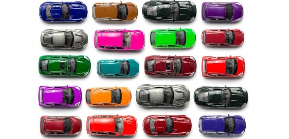 An arrangement of 20 toy cars in various colours next to each other.