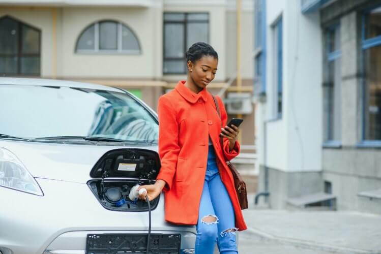 A lady charging her electric vehicle ahead of her travels.