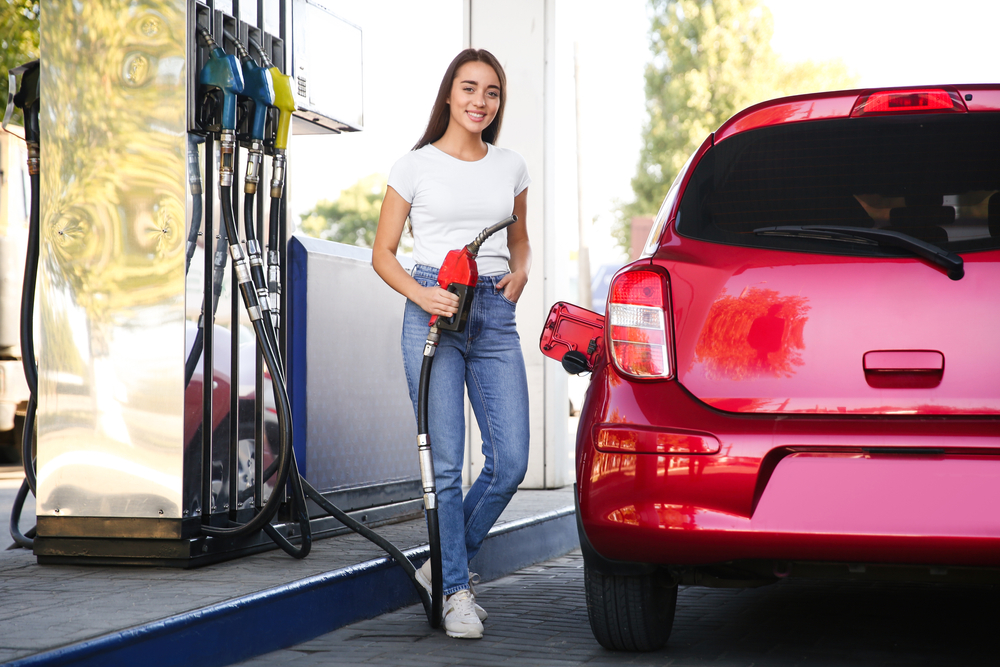 Smiling Hispanic woman wondering about her average mileage per tank of gas