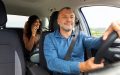 Conductor con su auto y licencia en mano, mostrando los requisitos para trabajar con Uber o Lyft.