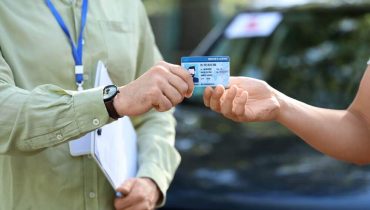 Persona entregando su licencia de conducir durante una cita para obtener o renovar la licencia de conducir.