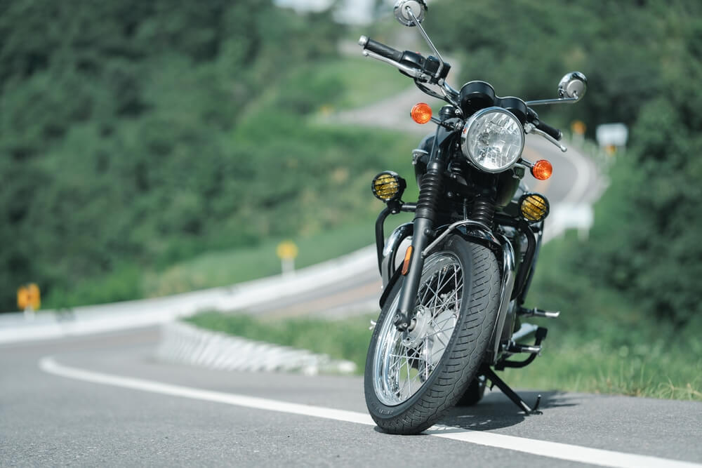 Classic motorcycle parked on a winding rural road, representing protection with seguro de moto clásica o de colección.