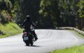 Motorcyclist riding on a forest road, illustrating coverage options with seguro de moto clásica o de colección.
