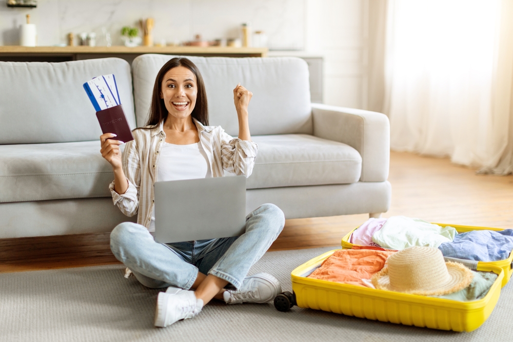 Mujer empacando y mostrando pasaporte en casa, representando la preparación para viajar con residencia americana.