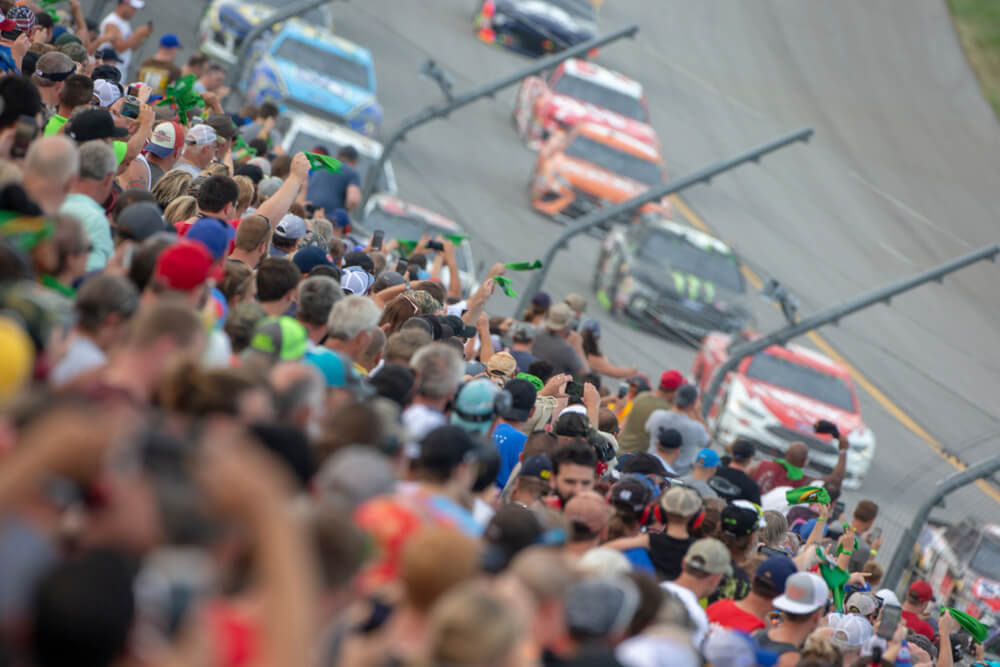 Aficionados llenan las gradas mientras los autos compiten a gran velocidad, reflejando la pasión y el ambiente que han acompañado las grandes rivalidades históricas de NASCAR.