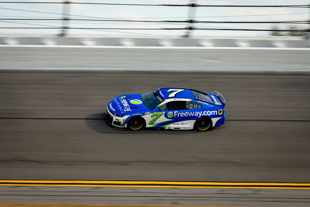 Auto de NASCAR patrocinado por Freeway compitiendo durante una carrera de la Cup Series, destacando la estrategia de competencia bajo la Choose Rule de NASCAR.