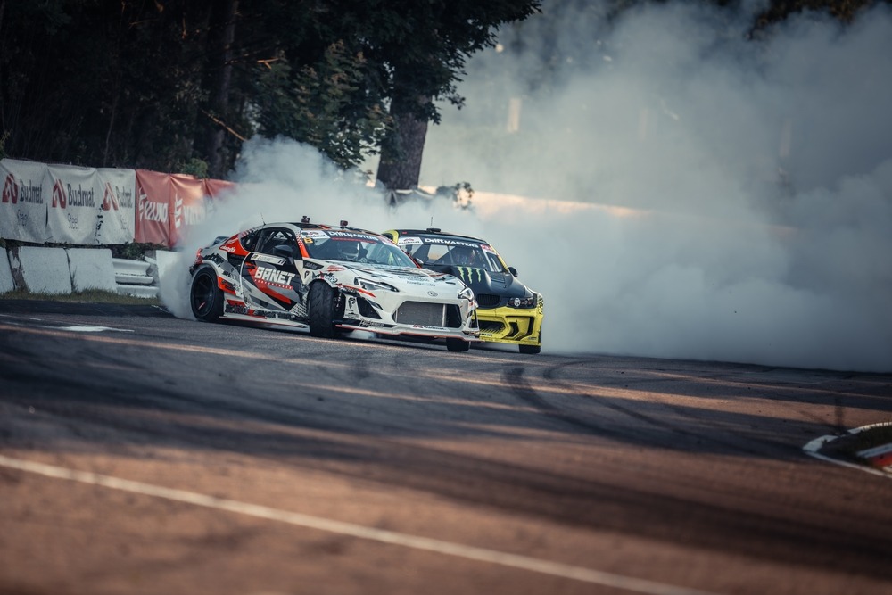 Autos de carreras derrapando en pista durante una competencia de automovilismo.