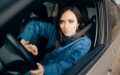 Mujer al volante de su auto con cinturón de seguridad, relacionado con cambiar de compañía de seguros mientras tienes un SR-22.