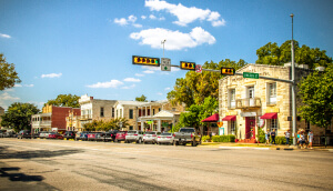 Calle Principal de Fredericksburg, Texas conocida como "La Milla Mágica", con tiendas y personas caminando – Seguro de auto barato en Fredericksburg, Texas.