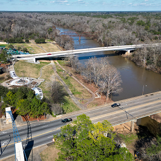 Vista aérea con dron de la intersección del río en Albany, Georgia, mostrando el río Flint y autos circulando de manera segura sin accidentes. Seguro de auto barato en Georgia.
