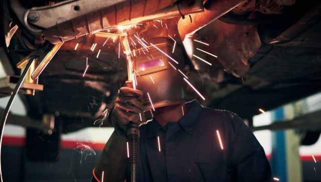 Mecánico reparando un auto para evaluar cuándo conviene reparar o reemplazar un auto.
