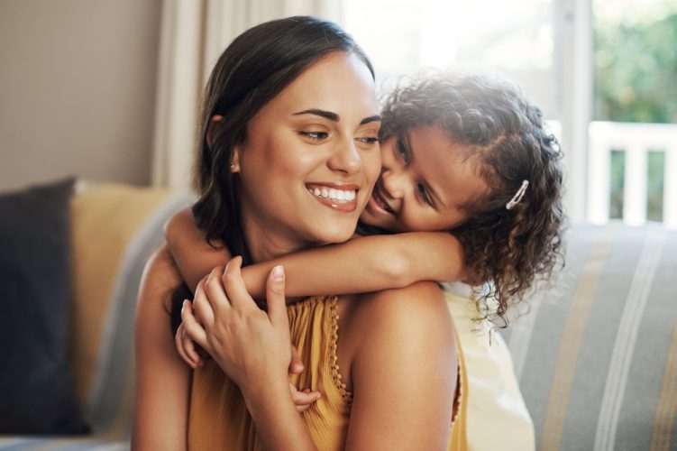 Mom and daughter cuddle on the couch - life insurance for single moms.