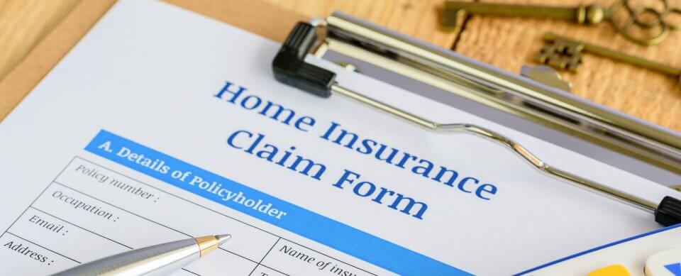 A clipboard with a form that reads Home Insurance Claim Form to illustrate how to file a home owner's insurance claim.