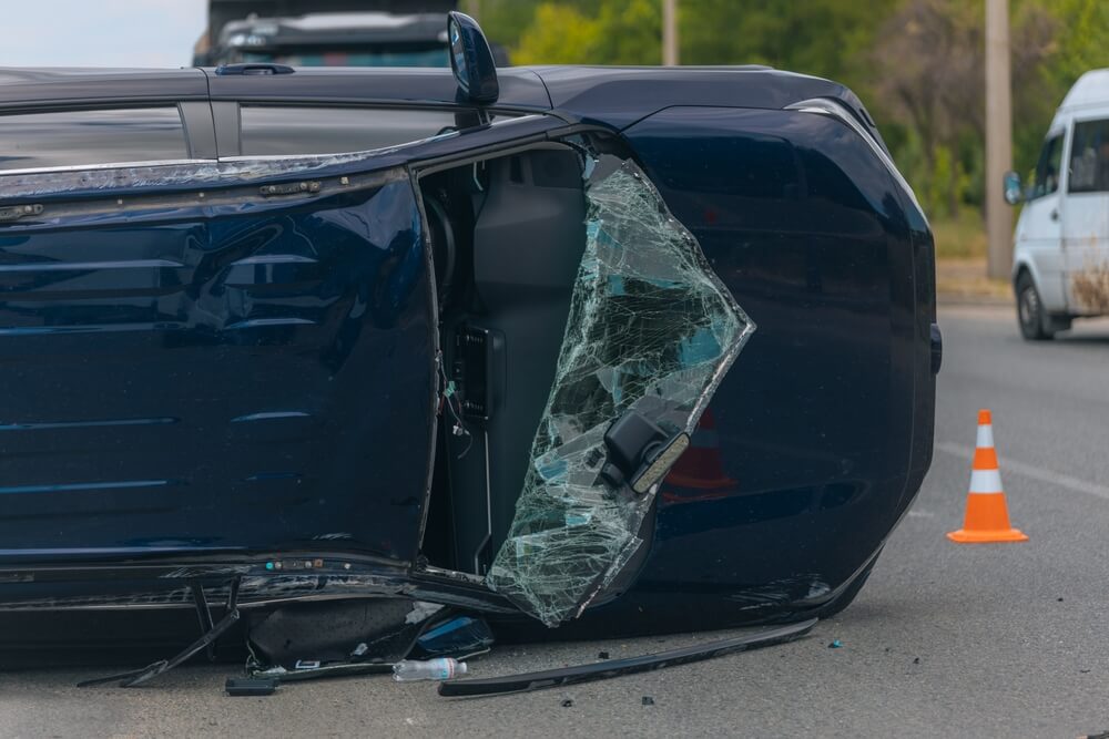Overturned vehicle after a crash highlighting the financial risks of an auto insurance lapse.