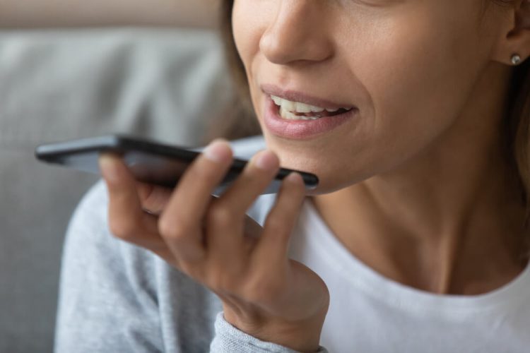 Woman speaks into phone, concept of sending a message without hands.