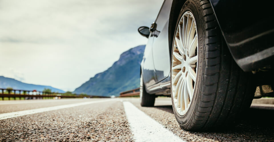 Ant view of a parked car next to the division line of a road that illustrates whether you are using proper lane etiquette when you drive.