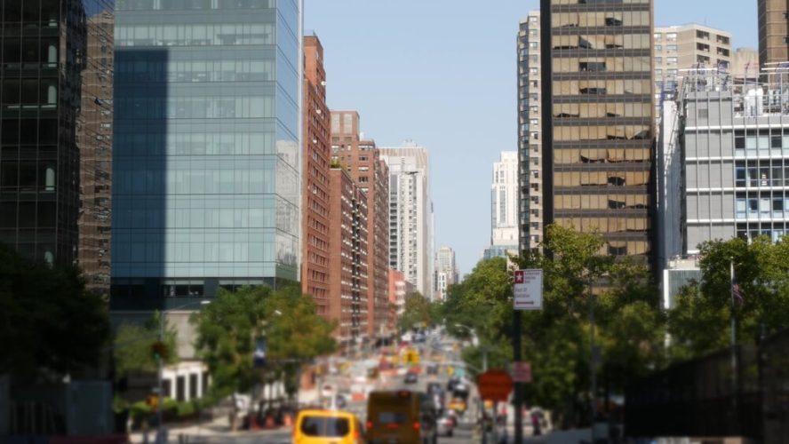 New York City street with traffic and high-rise buildings, highlighting the urban setting for New York car insurance requirements and coverage.