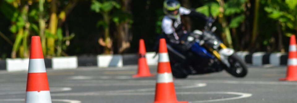 A man riding a Motorcycle riding through motorcycle safety course to illustrate 3 reasons you need to take a motorcycle safety course.
