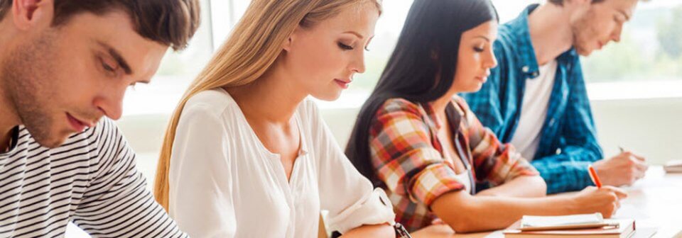 Group of college students in class taking notes who portrays whether renters insurance for college students make sense.