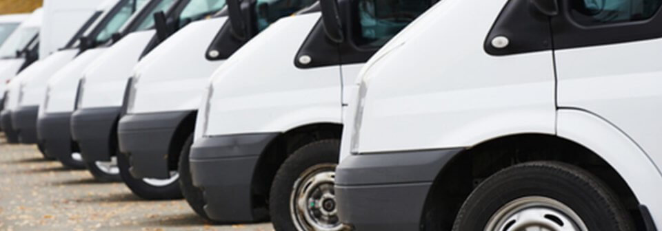 Row of commercial trucks parked outside of business to depict what is commercial vehicle insurance.