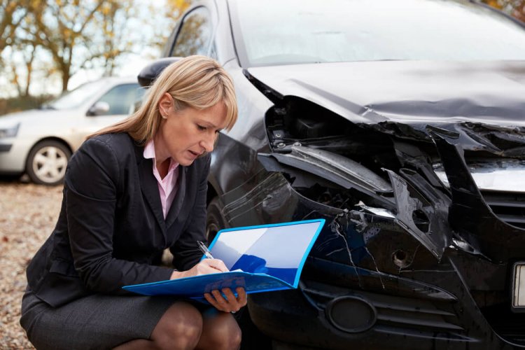Female Loss Adjuster Writing Report On Damaged Car and illustrating what to know if you have an accident in a leased vehicle.