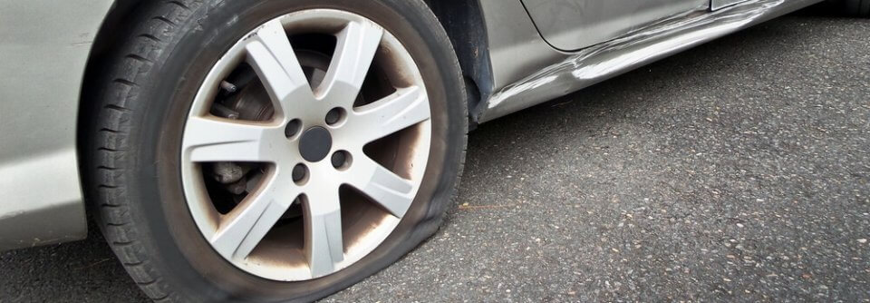 Close up of a flat tire that blew up because the driver did not change it when it was too bald.