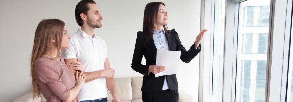 Young couple looking at apartment for rent with a landlord after considering various things to think about before renting an apartment