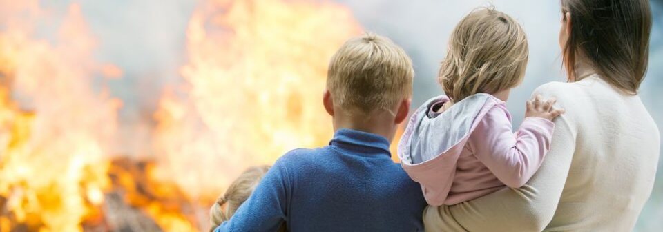 Mother with children watching their house burn down illustrating how to keep your home safe from fire.