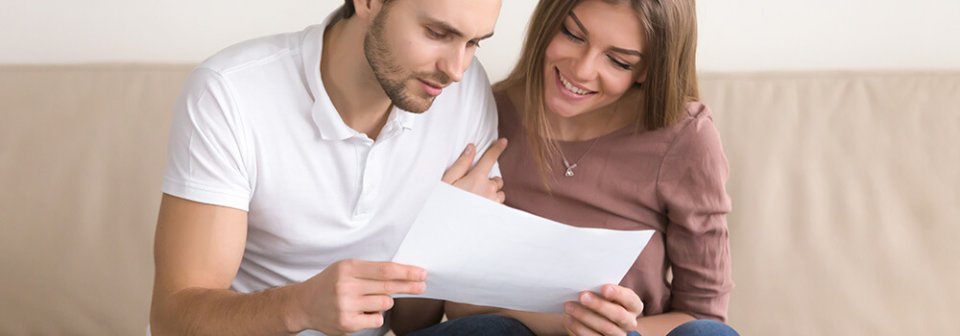 A young couple looking at renter's insurance policies to depict 4 common renter's insurance myths.