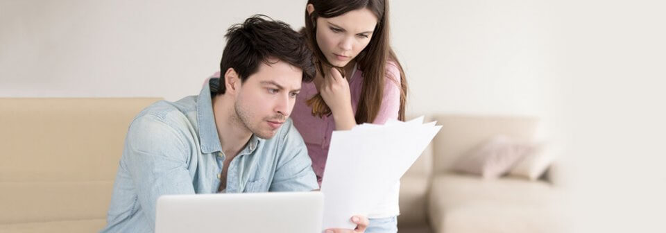 A young Caucasian couple reviewing insurance policies and depicting common health insurance questions.