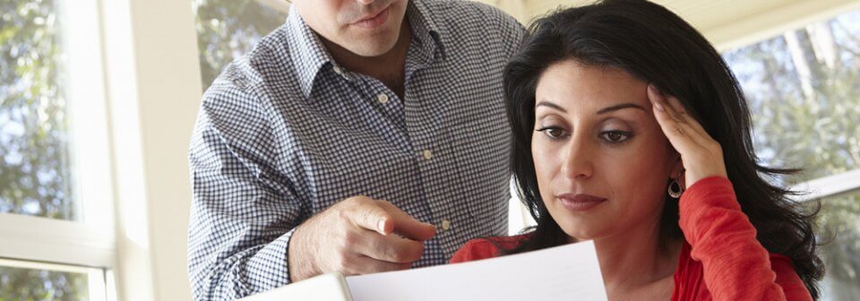 A middle-age, latino woman looking at an insurance policy in confusion and portraying how to read and understand your auto insurance policy.
